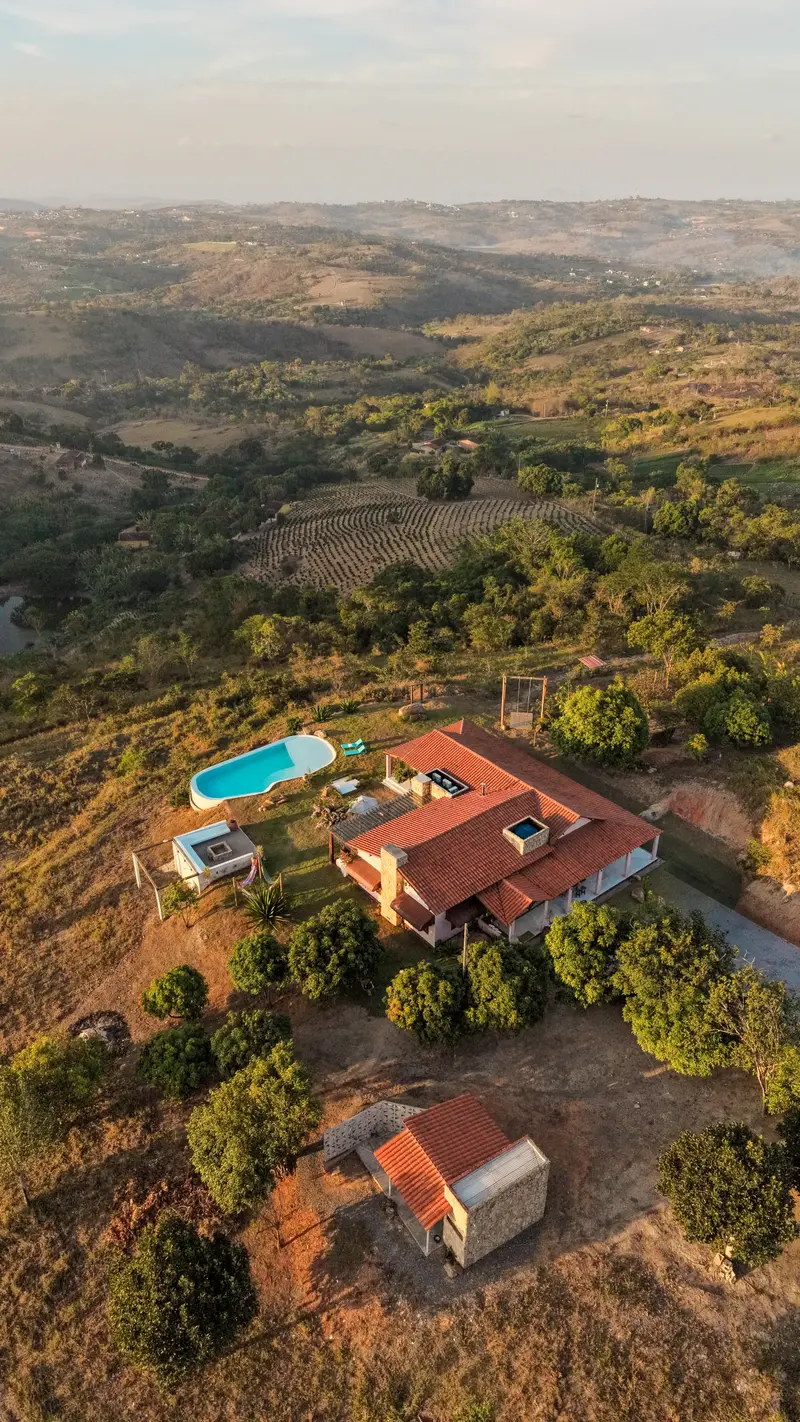 Vista aérea da casa e da piscina na luz dourada do fim de tarde