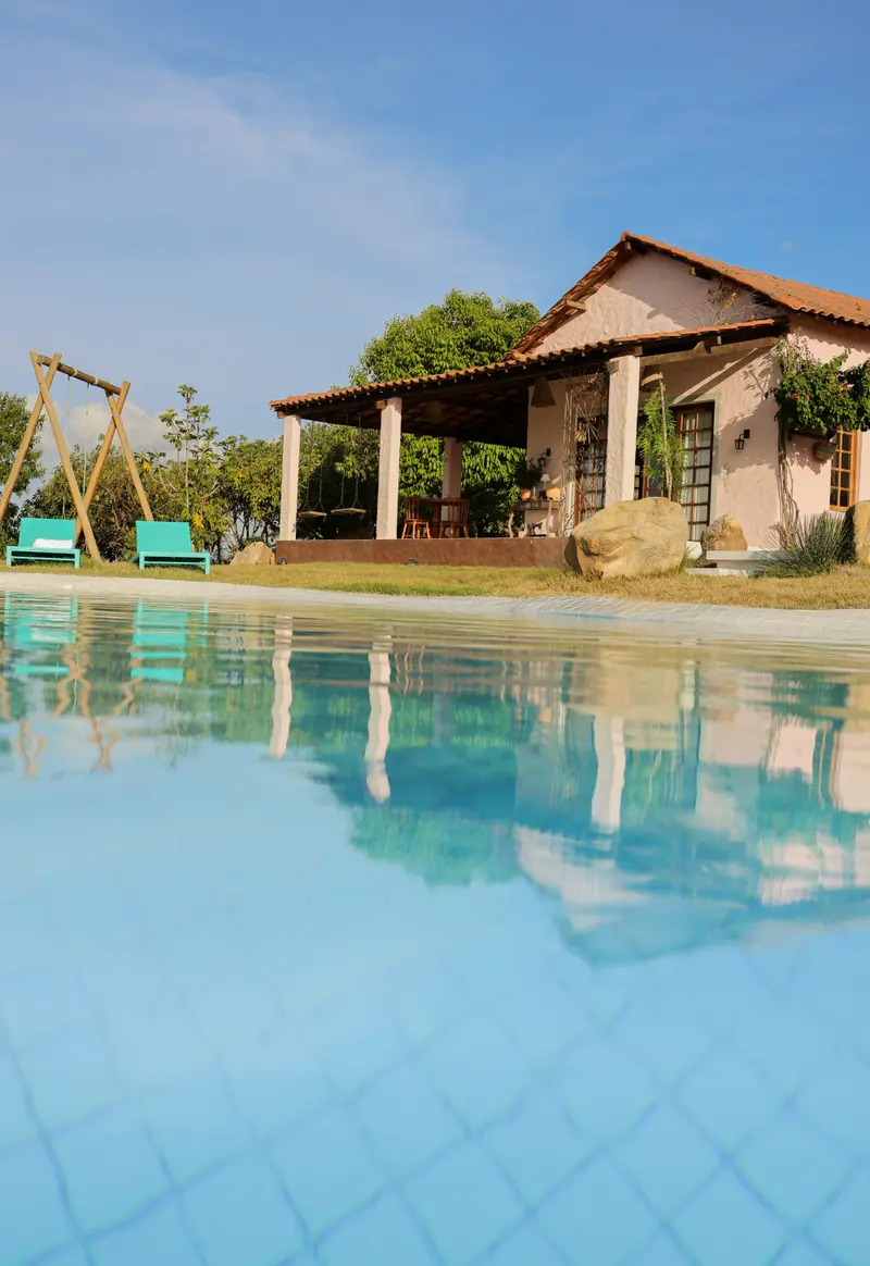 Casa refletida na piscina, em enquadramento vertical