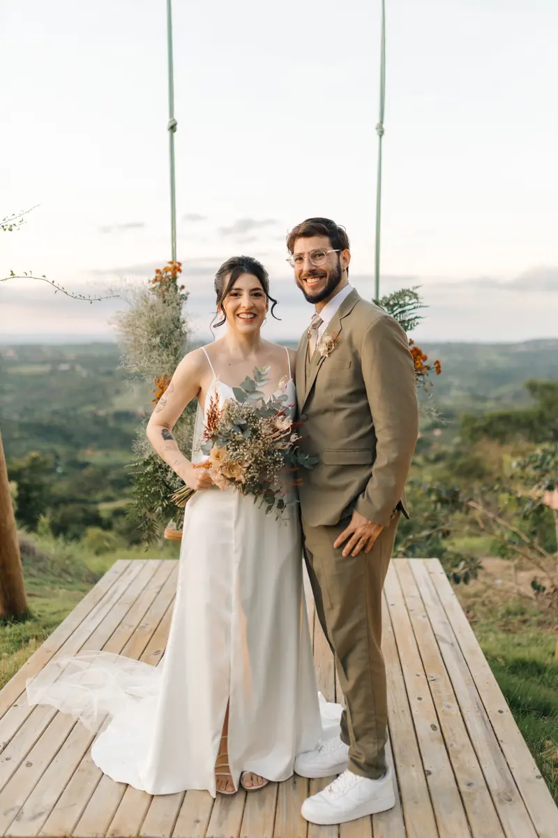 Casal de noivos na plataforma do balanço, com a paisagem ao fundo