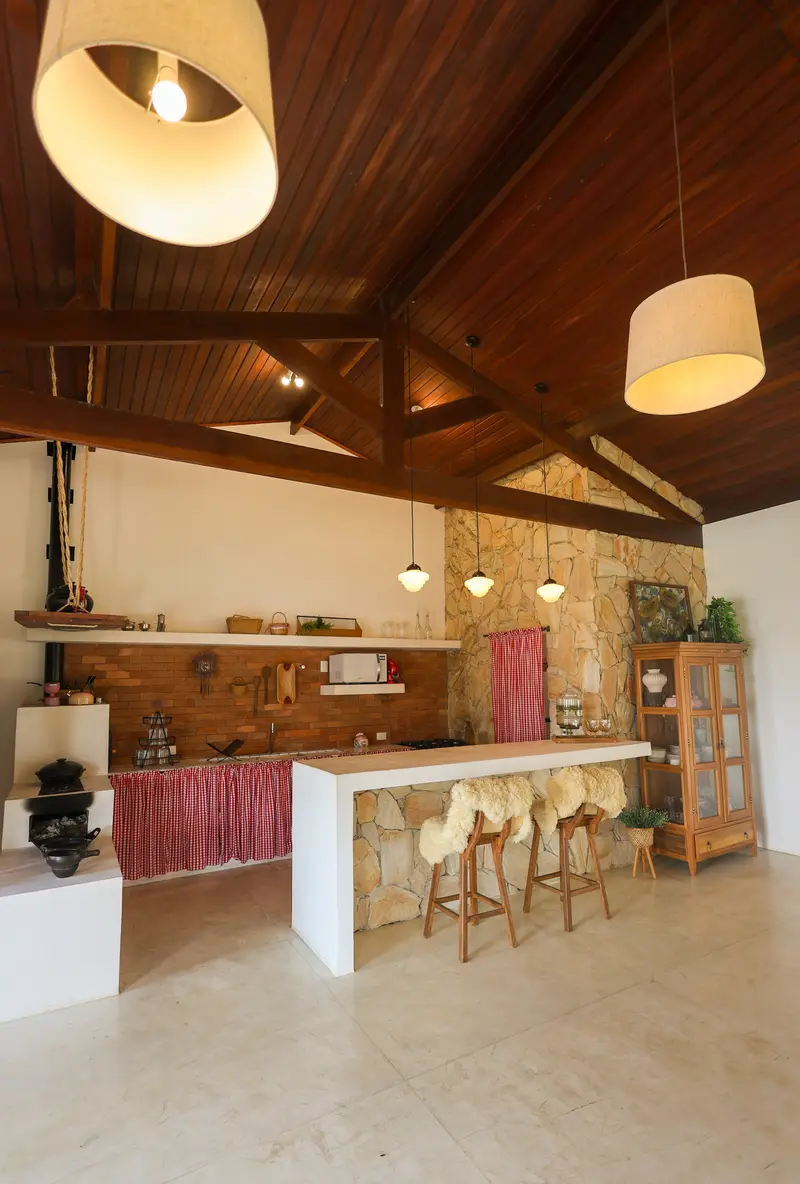 Cozinha aberta com bancada de pedra e banquetas