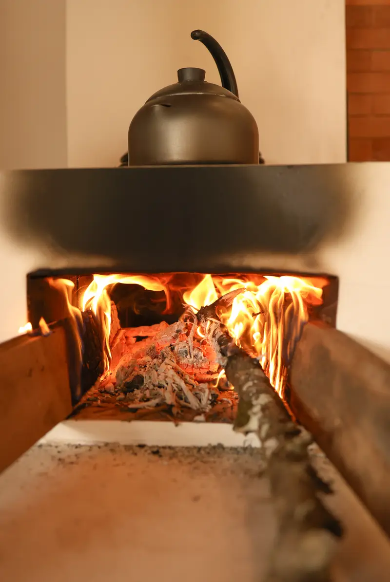 Fogão a lenha com chaleira em um canto da cozinha