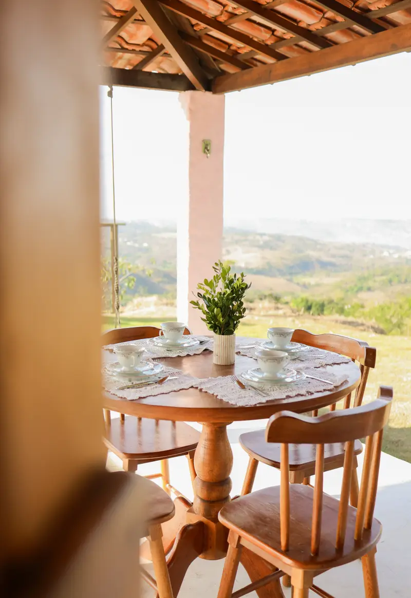 Mesa posta na varanda com a paisagem ao fundo