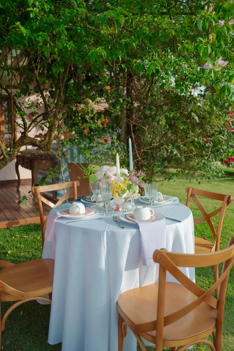 Mesa posta com louças e flores para um almoço de celebração
