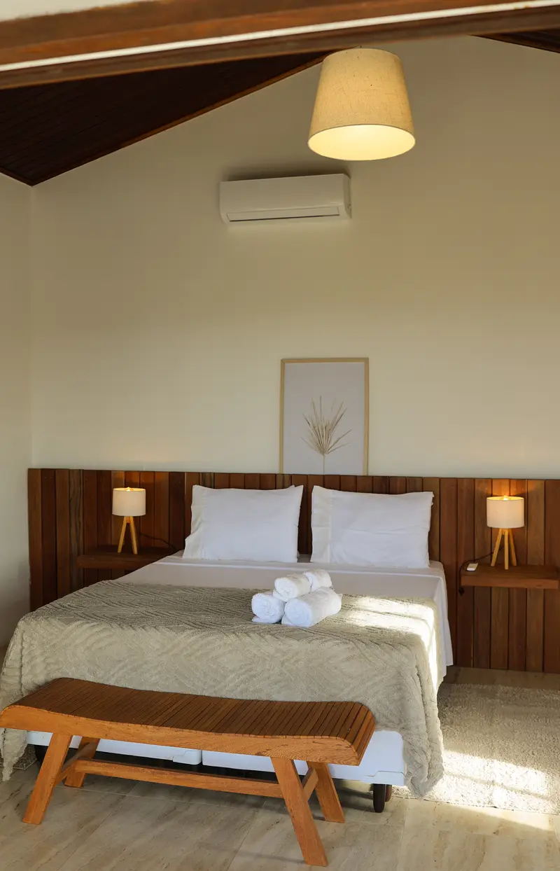 Cama de casal com abajures e tons de areia