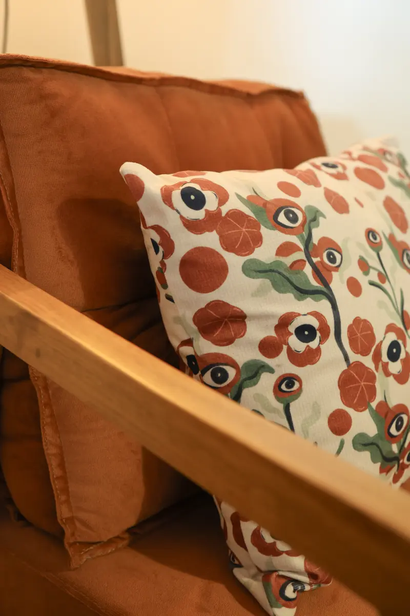 Poltrona cor de terracota e almofada em um dos quartos