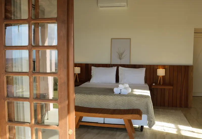 Quarto visto pela porta francesa, com luz natural entrando