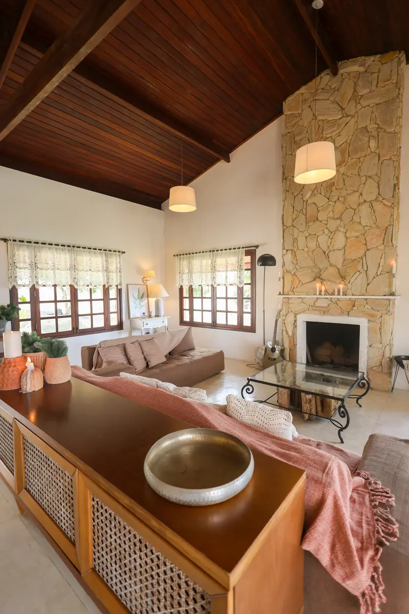 Sala de estar com lareira de pedra e sofá voltado para ela