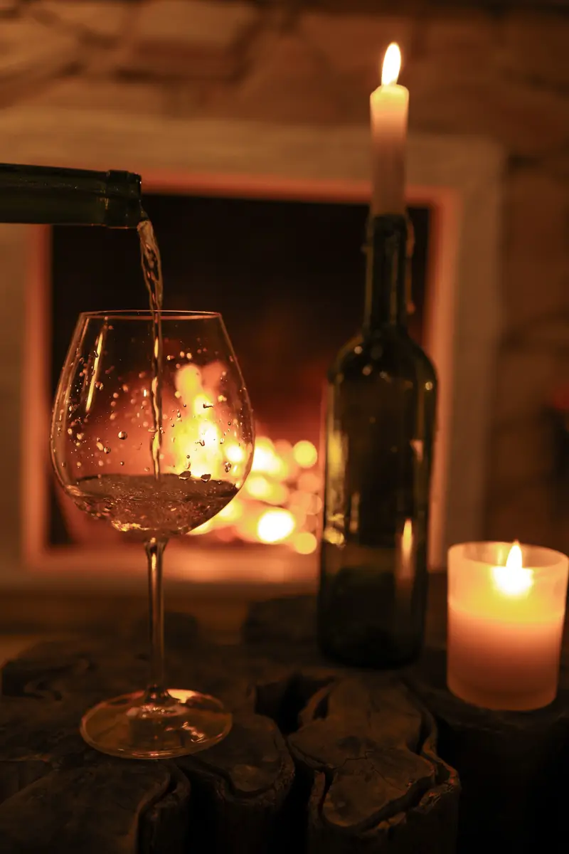 Taça de vinho diante da lareira acesa